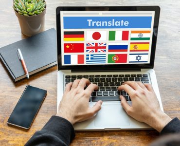 Man working on a laptop with the word translate on the computer screen